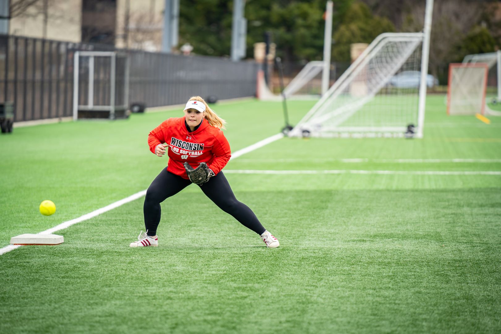 softball player feilding the ball at 3rd base